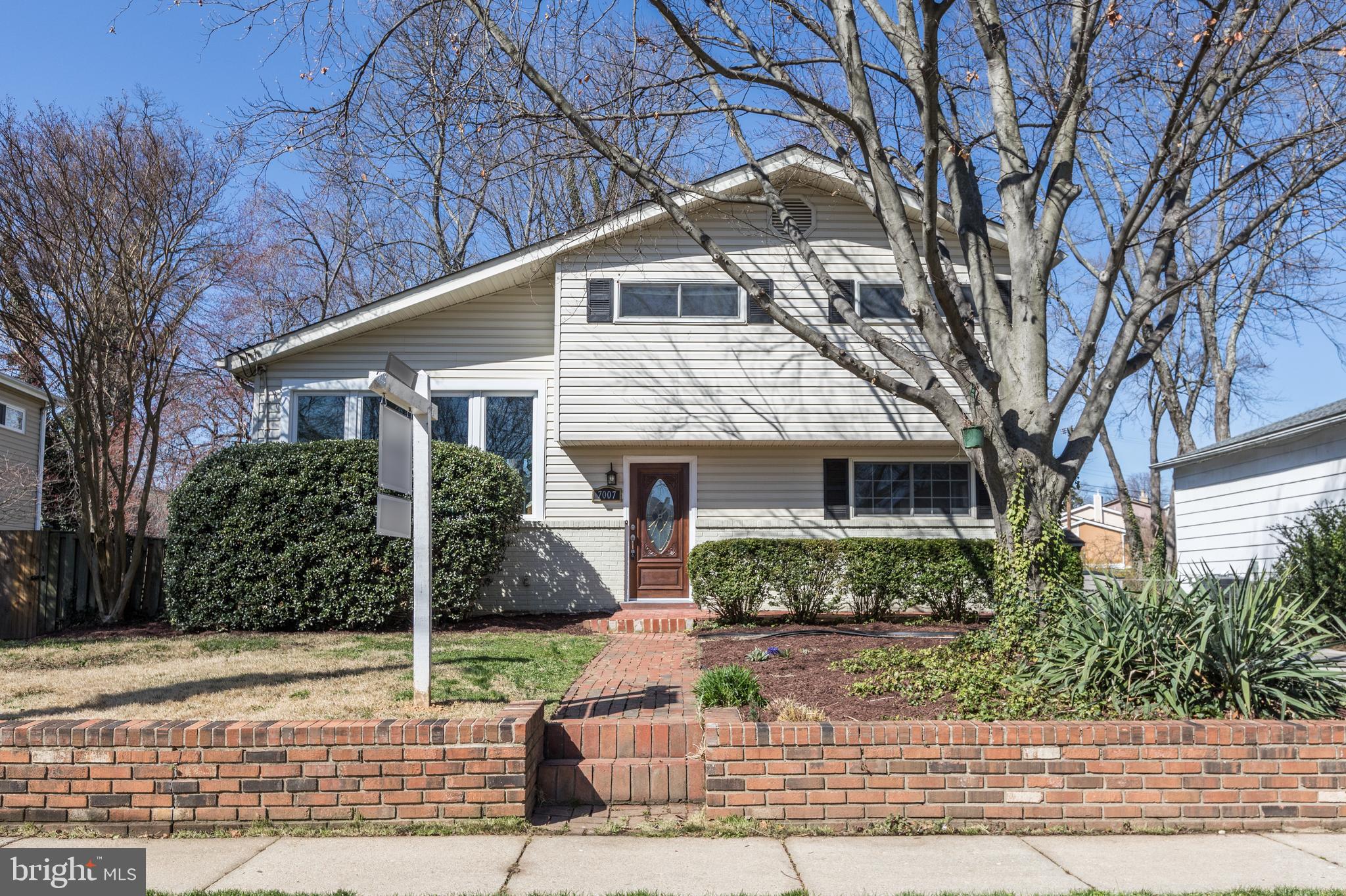 a front view of house with a yard and potted plants