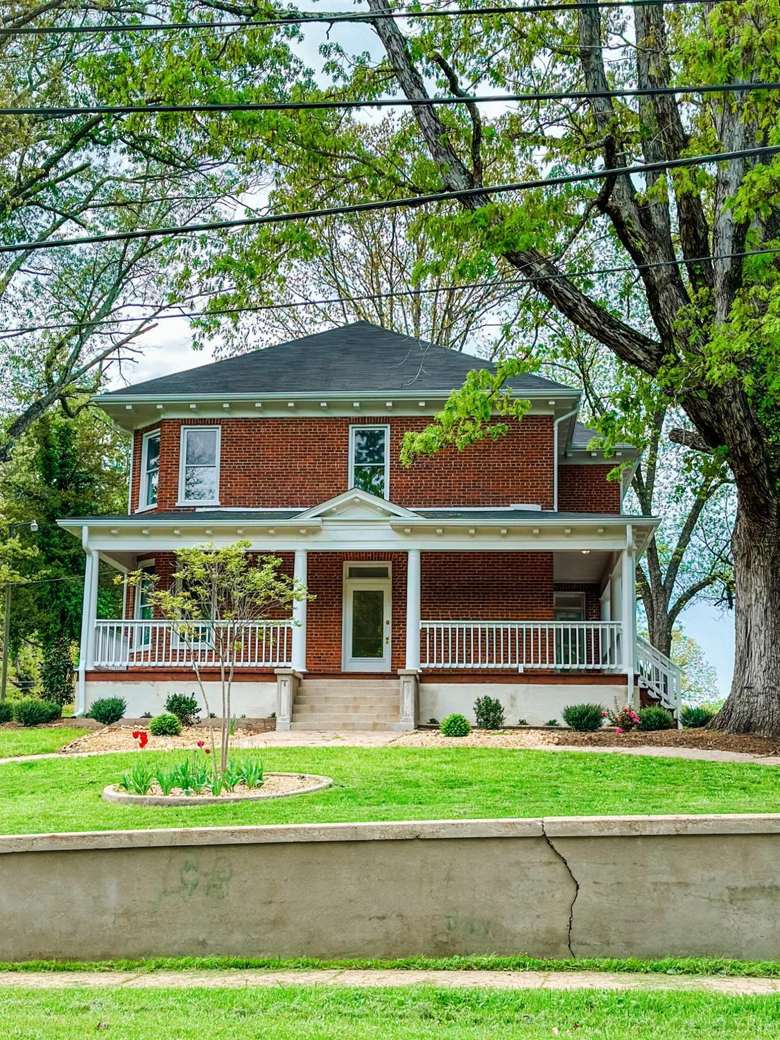 a front view of a house with a garden and plants