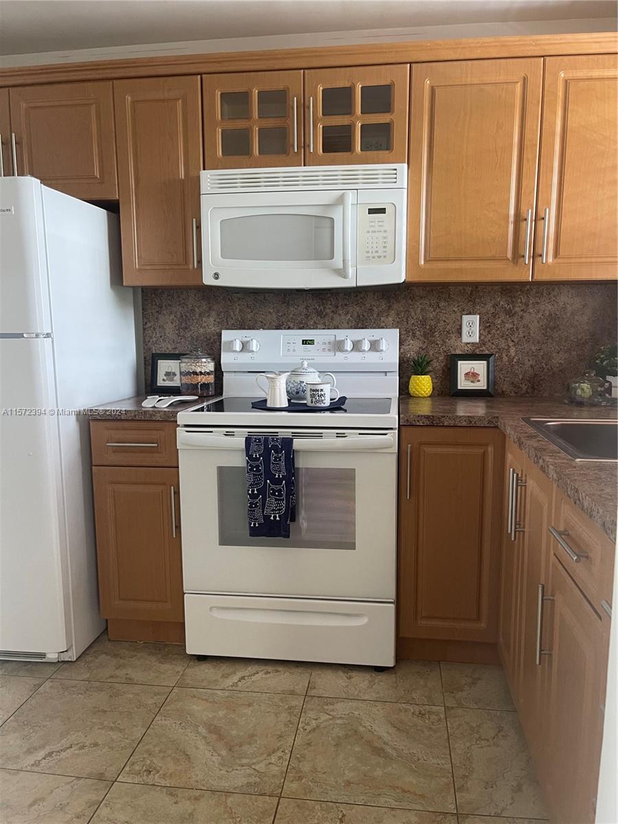 a kitchen with stainless steel appliances granite countertop a stove a microwave and a refrigerator