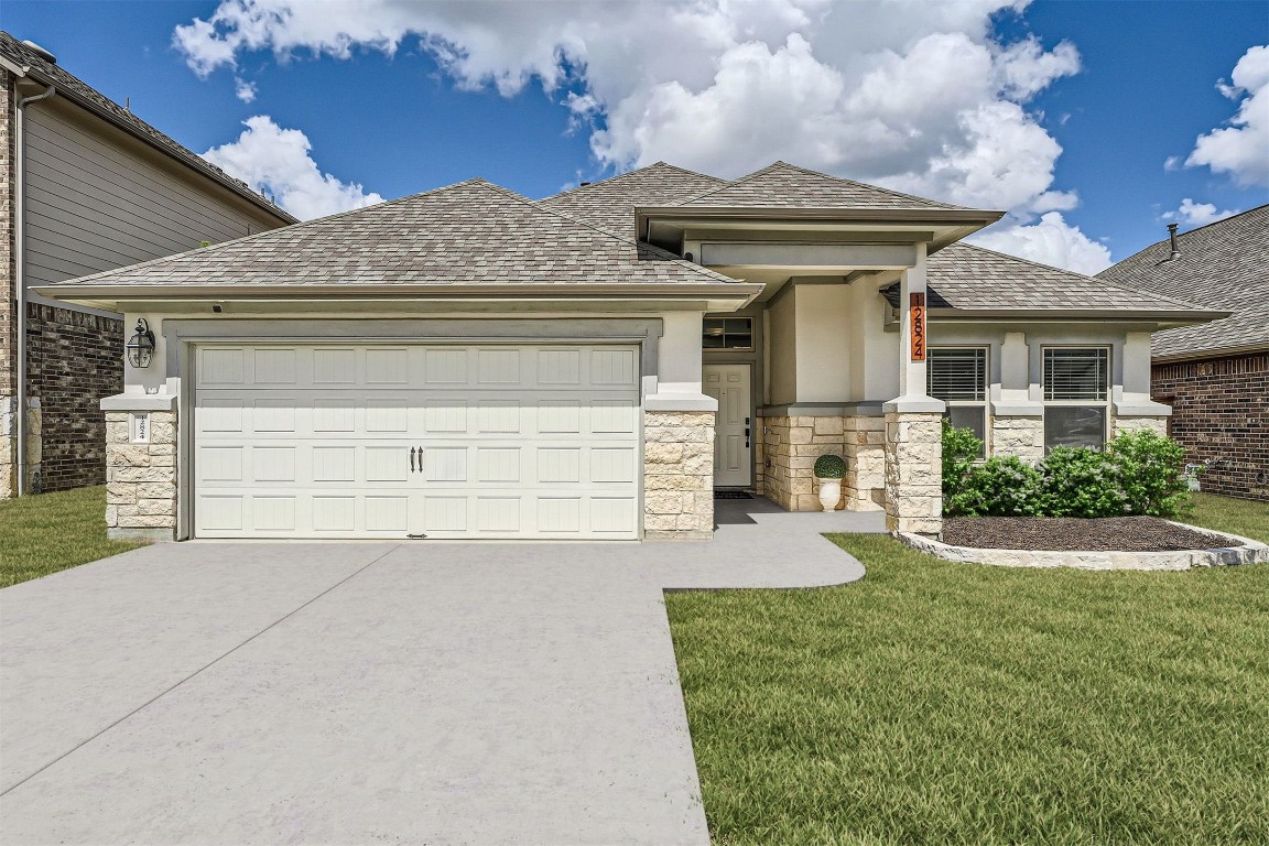 a front view of a house with a yard and garage