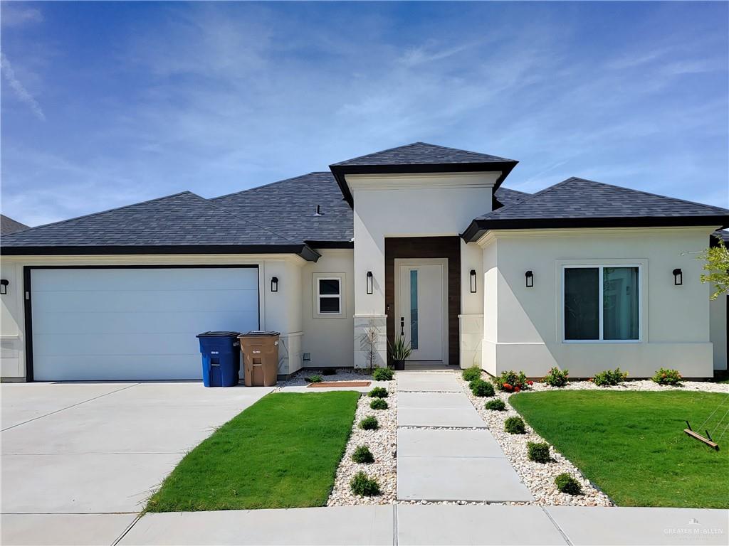 a front view of a house with a garden and yard