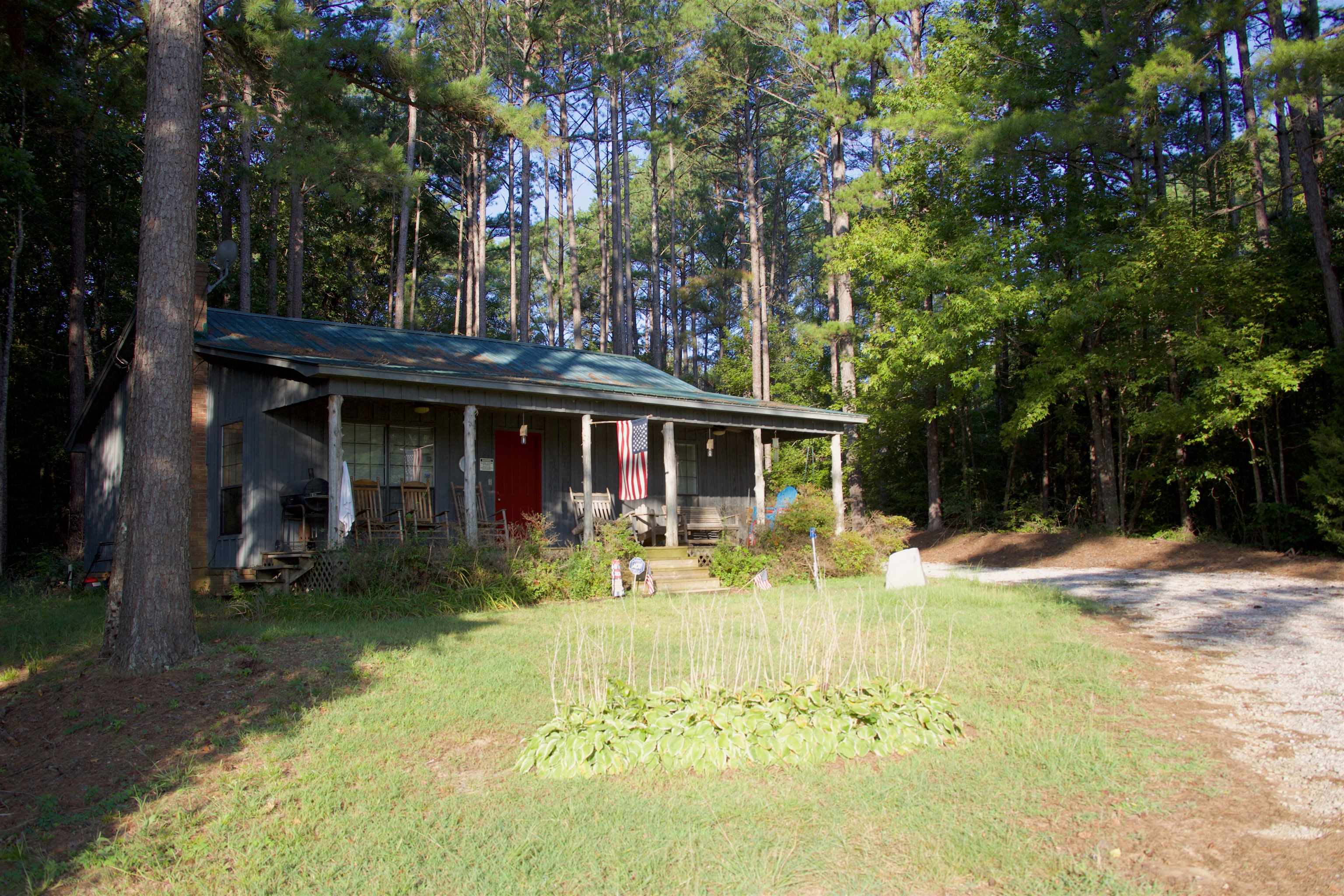 a view of a house with floor to ceiling windows and a tree