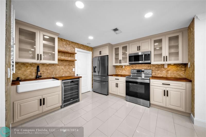 a kitchen with stainless steel appliances granite countertop a stove top oven a sink dishwasher and a refrigerator with wooden floor