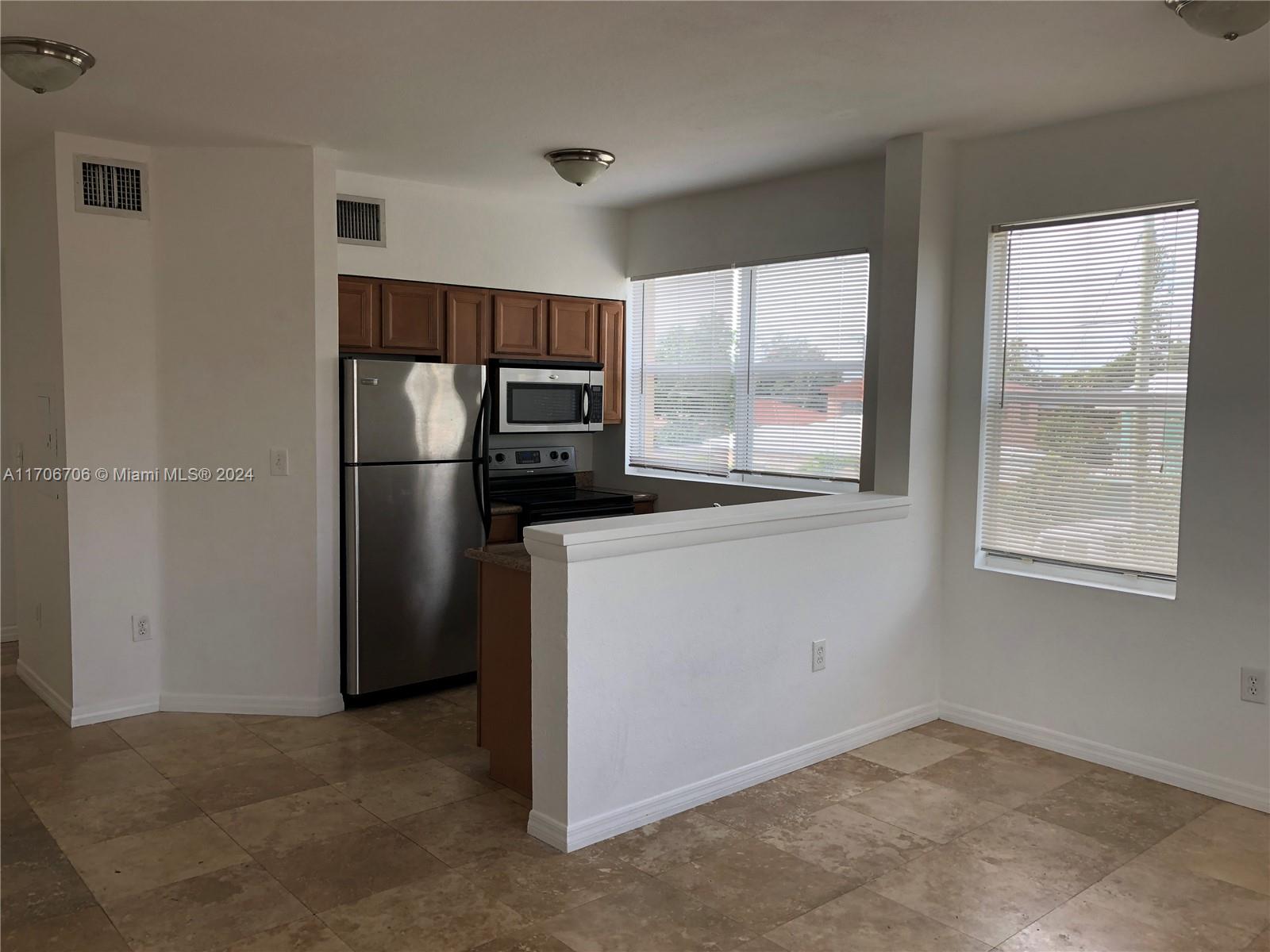 a kitchen with windows and refrigerator