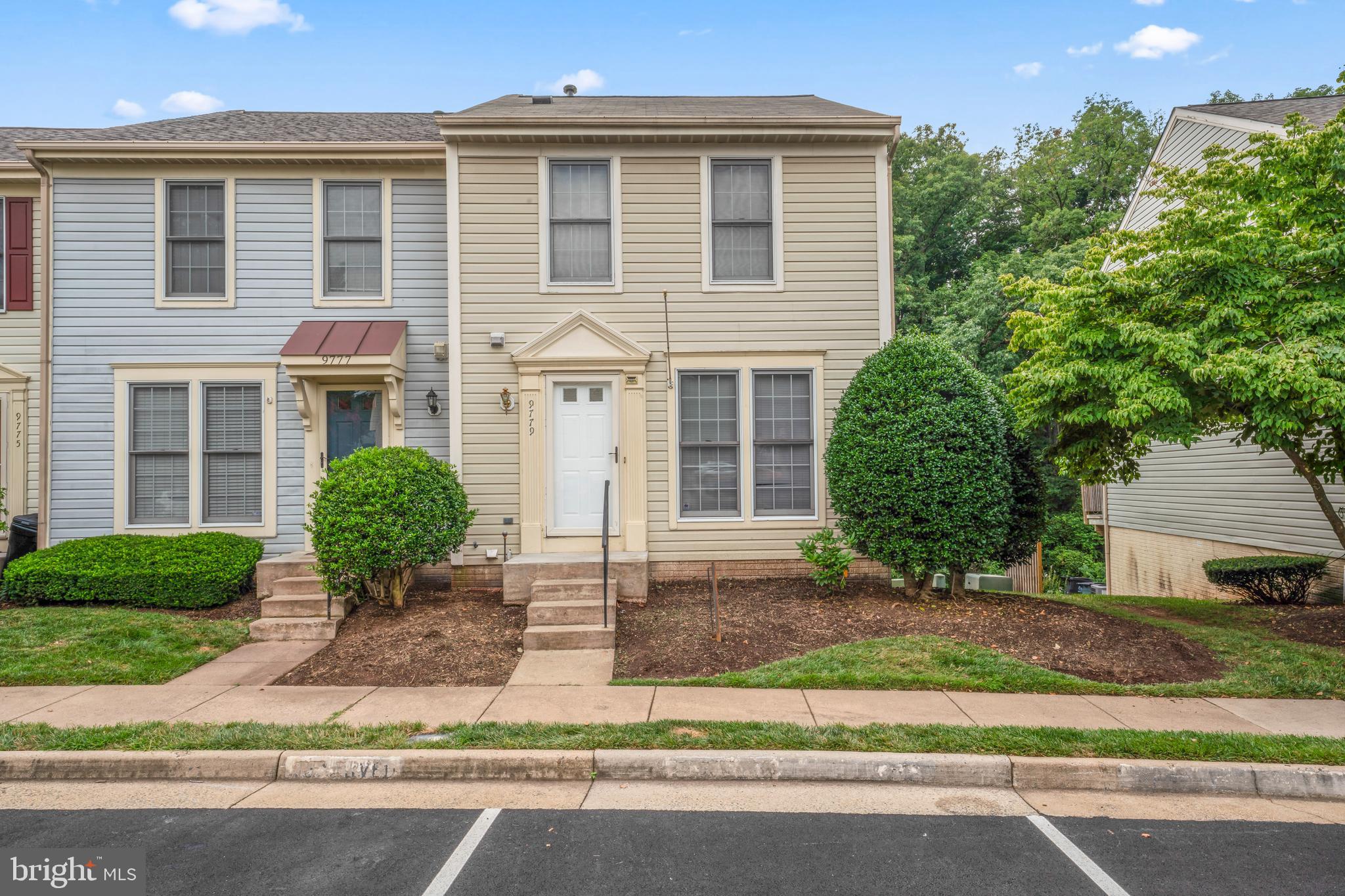 a front view of a house with a yard and potted plants