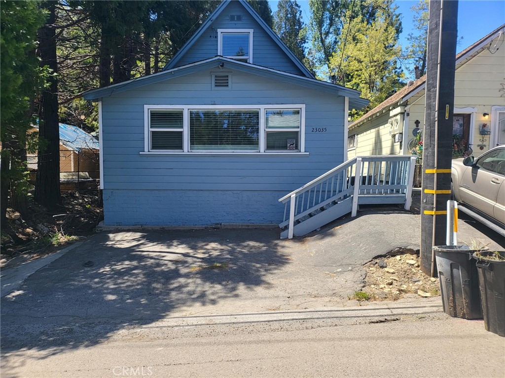 a front view of a house with a yard covered with snow