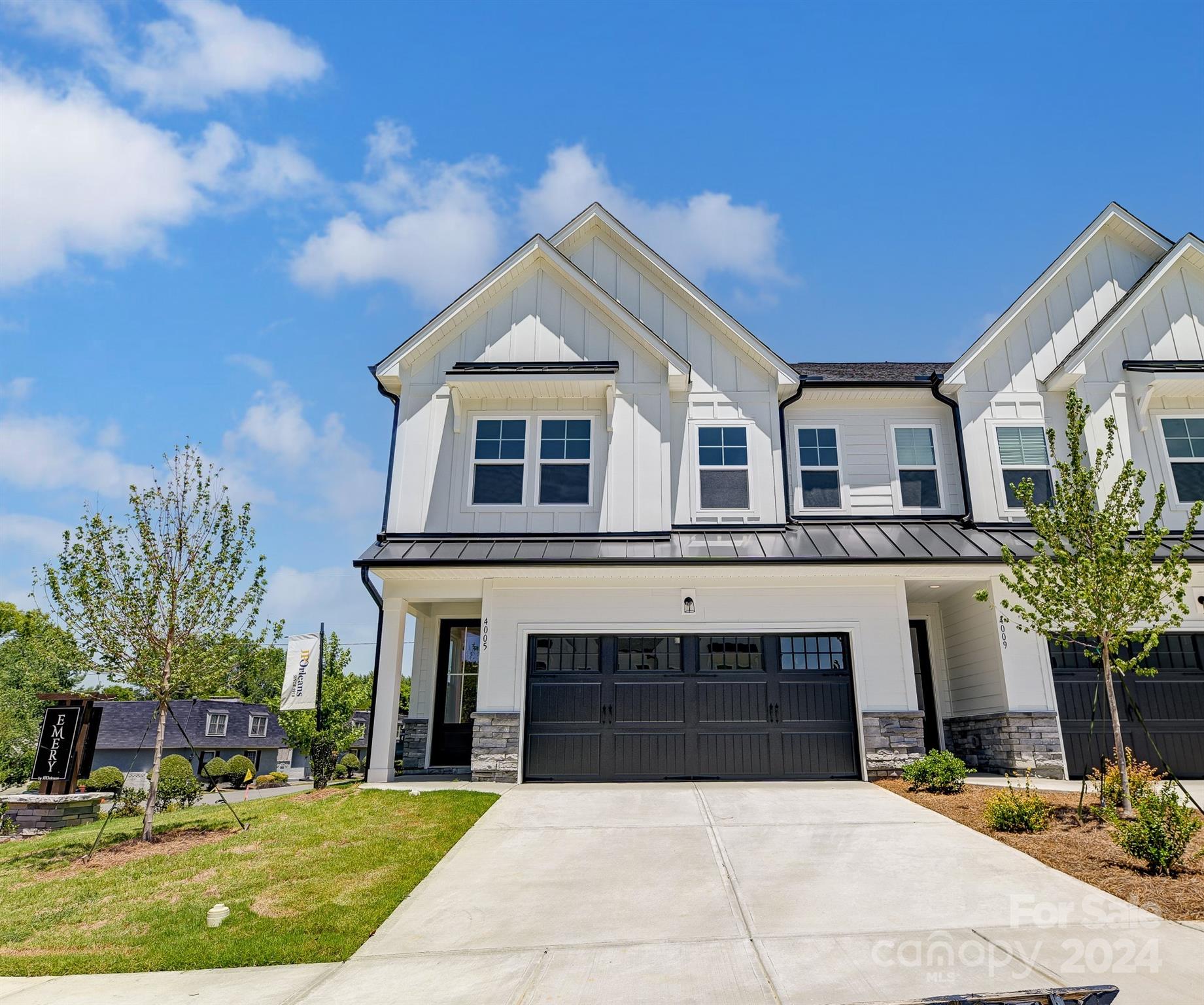 a front view of a house with yard and parking