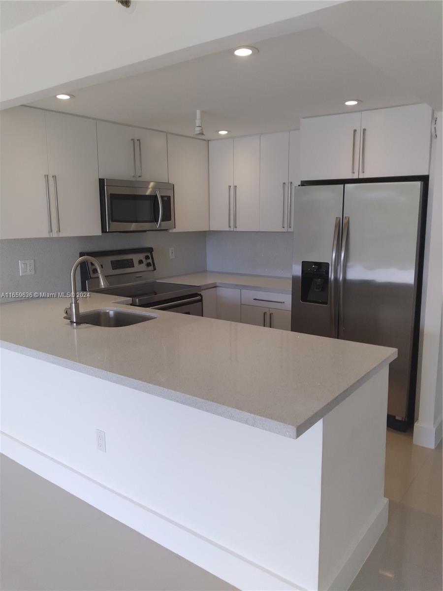 a kitchen with stainless steel appliances a refrigerator sink and microwave