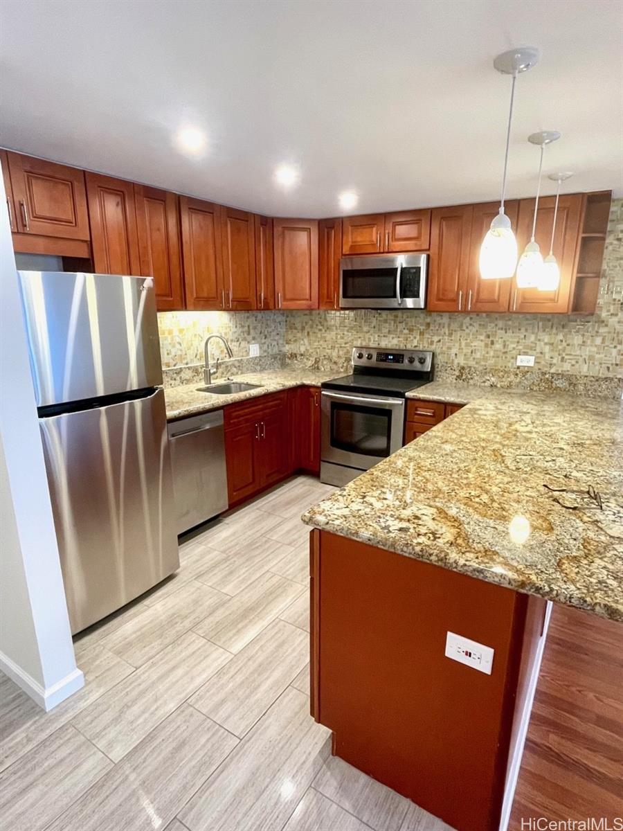 a kitchen with stainless steel appliances granite countertop a stove a sink and a microwave