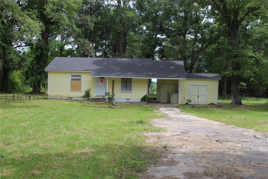 a view of a yard in front of a house with large trees