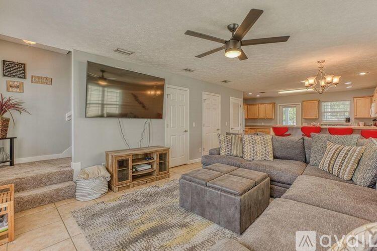 a living room with furniture kitchen view and a flat screen tv