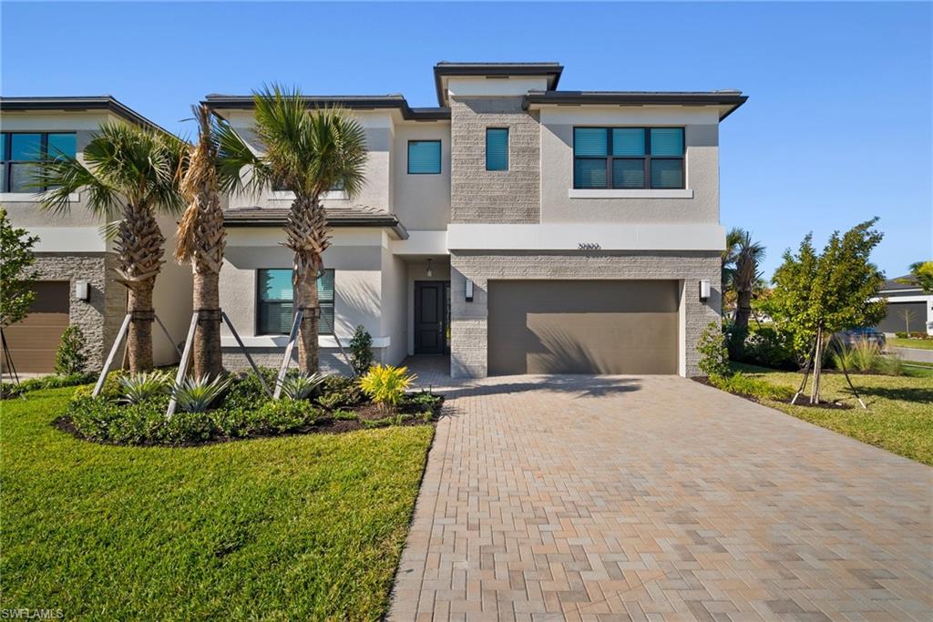 View of front of home featuring a garage and a front yard