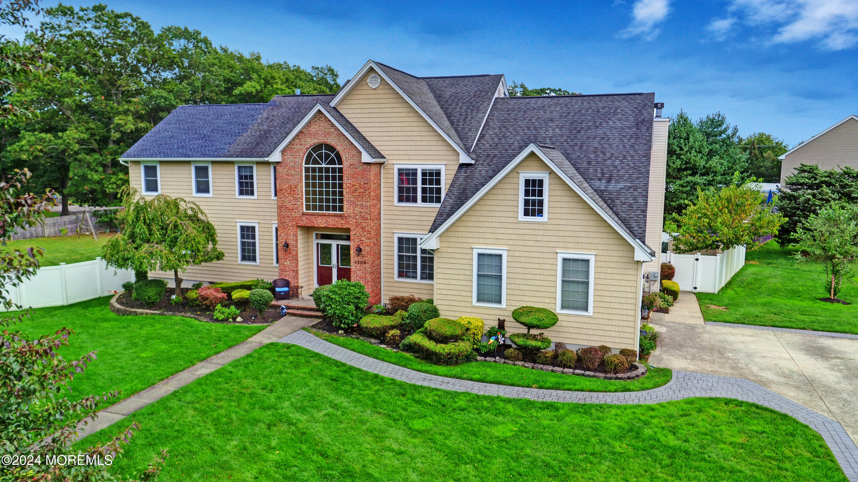 a front view of a house with a yard and green space