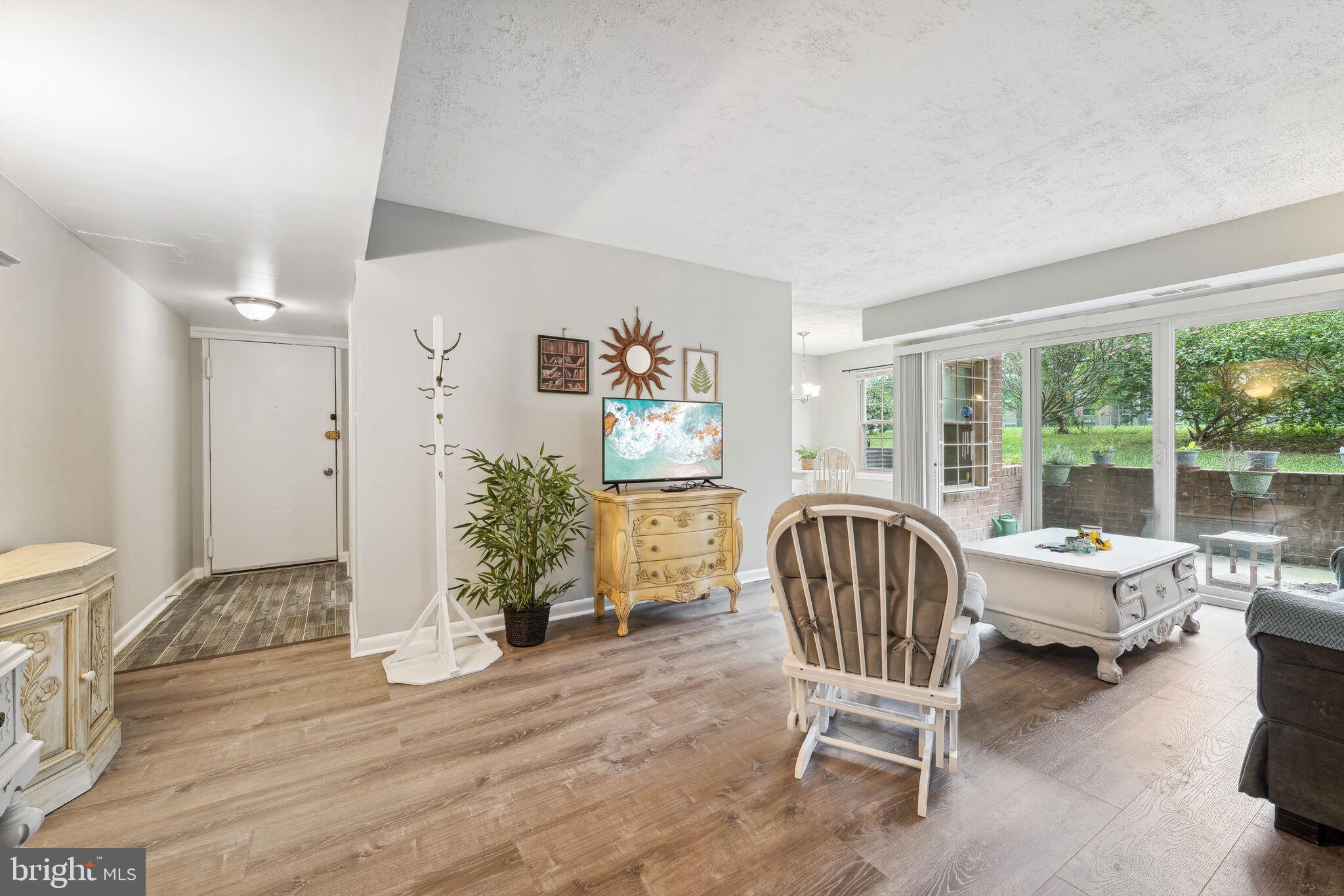 a living room with furniture wooden floor and a large window