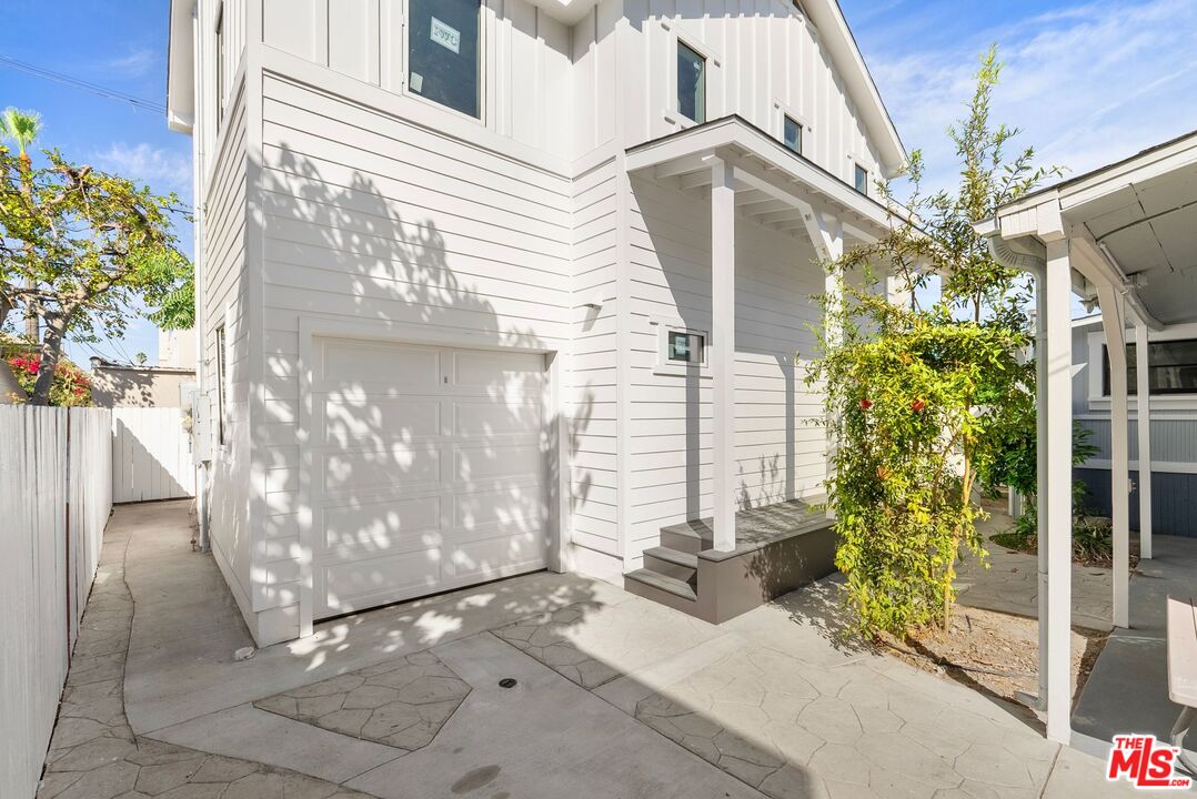 a view of a house with a yard and potted plants