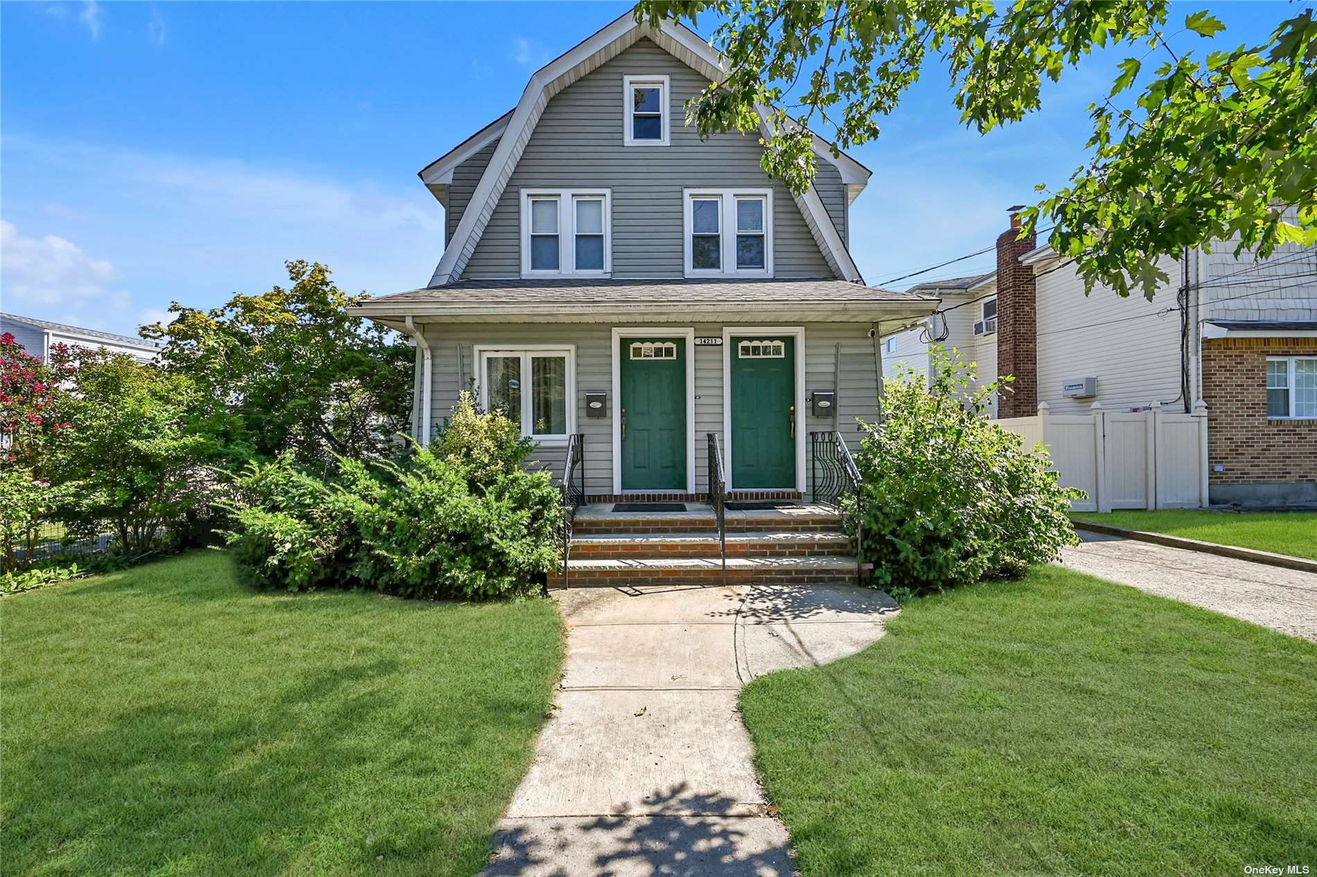 a front view of a house with a garden and yard