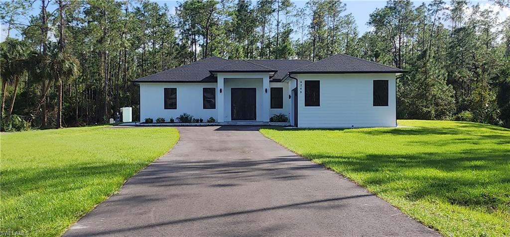 a front view of a house with yard and green space