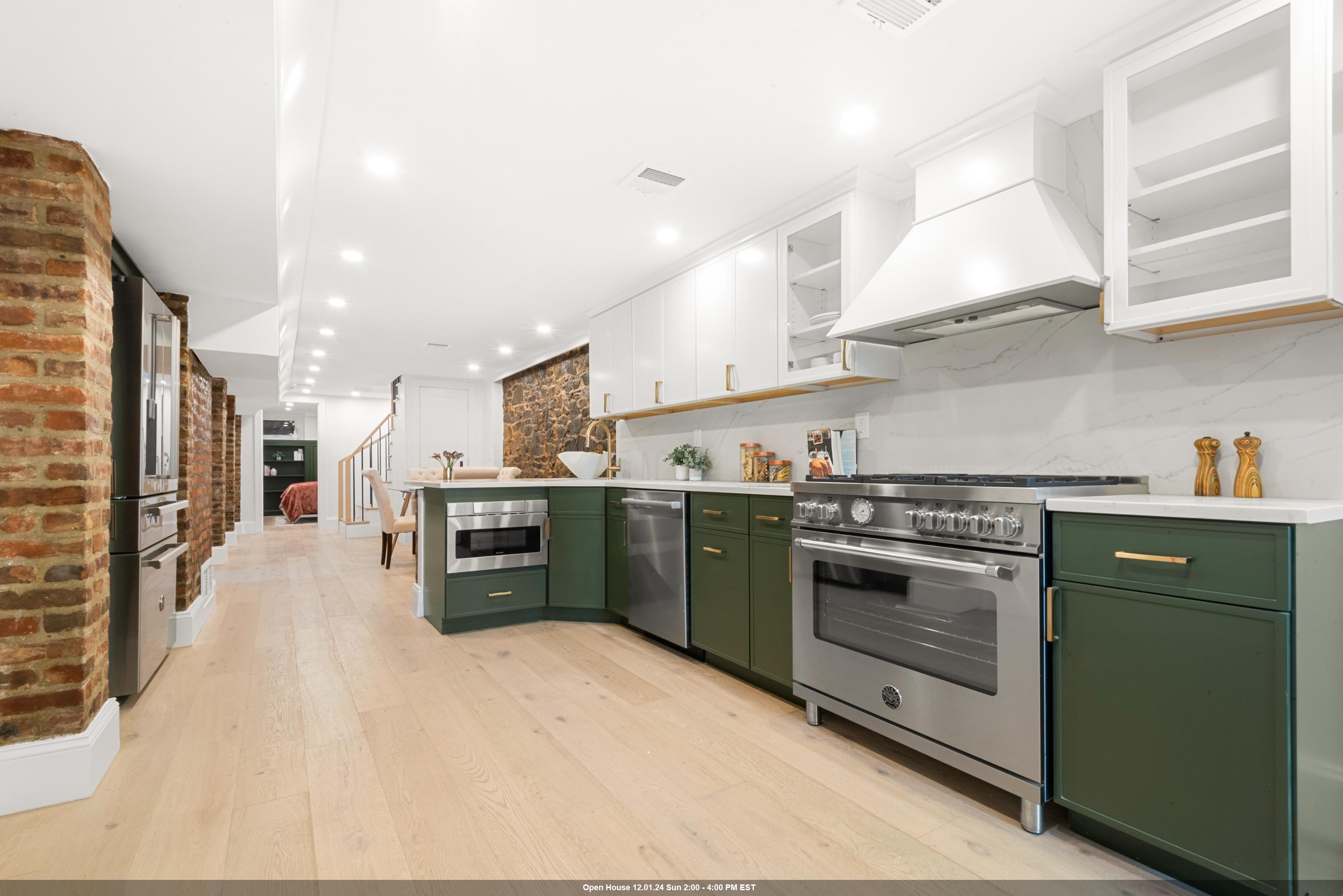 a kitchen with stainless steel appliances granite countertop a stove a sink and a refrigerator