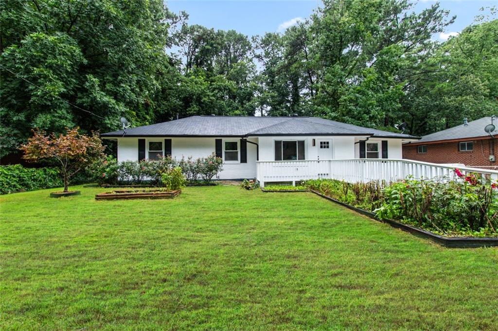 a front view of a house with a yard and green space