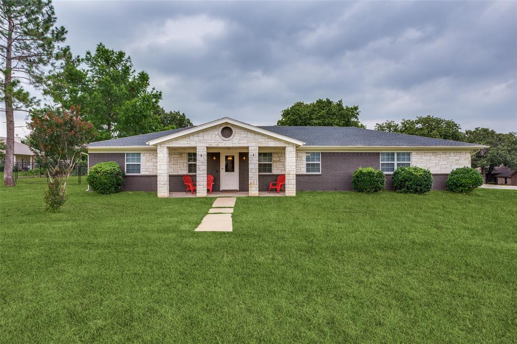 a front view of a house with a yard and green space