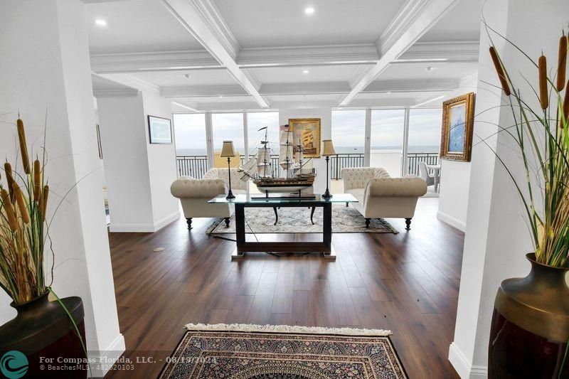 a living room with fireplace furniture and a large window