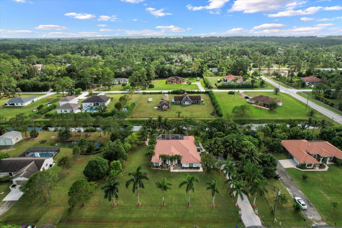 an aerial view of residential houses with outdoor space and trees