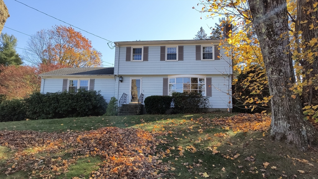 a view of a yard in front of a house with large tree