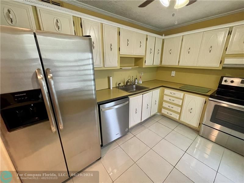 a kitchen with stainless steel appliances a refrigerator sink and cabinets