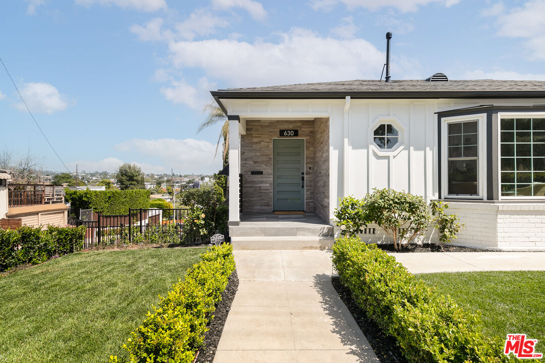 a front view of a house with a garden