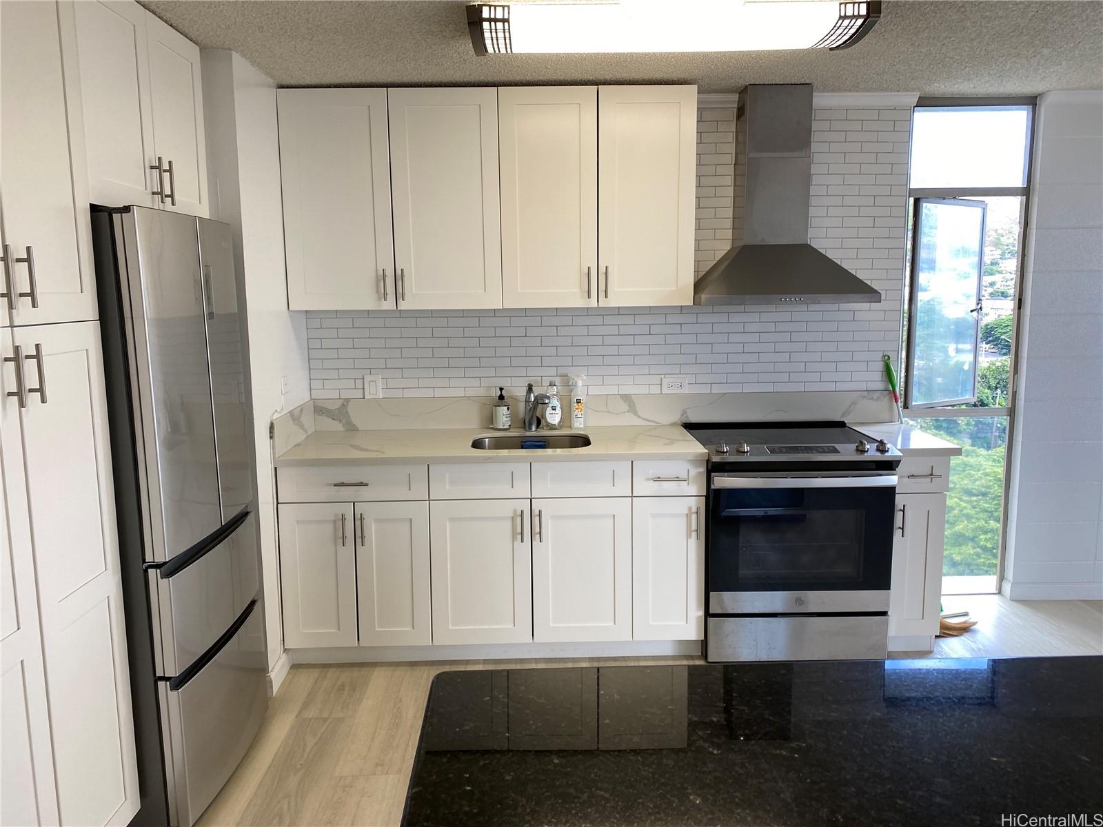 a kitchen with white cabinets and appliances