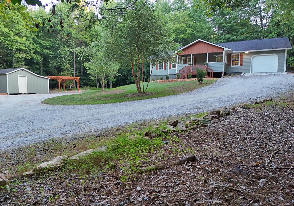 a front view of a house with a yard and trees