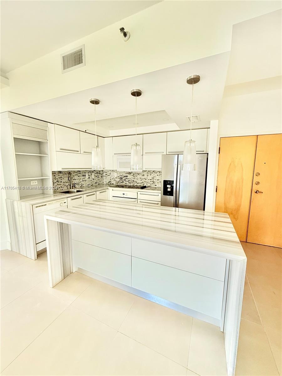 a view of kitchen with stainless steel appliances kitchen island sink and cabinets