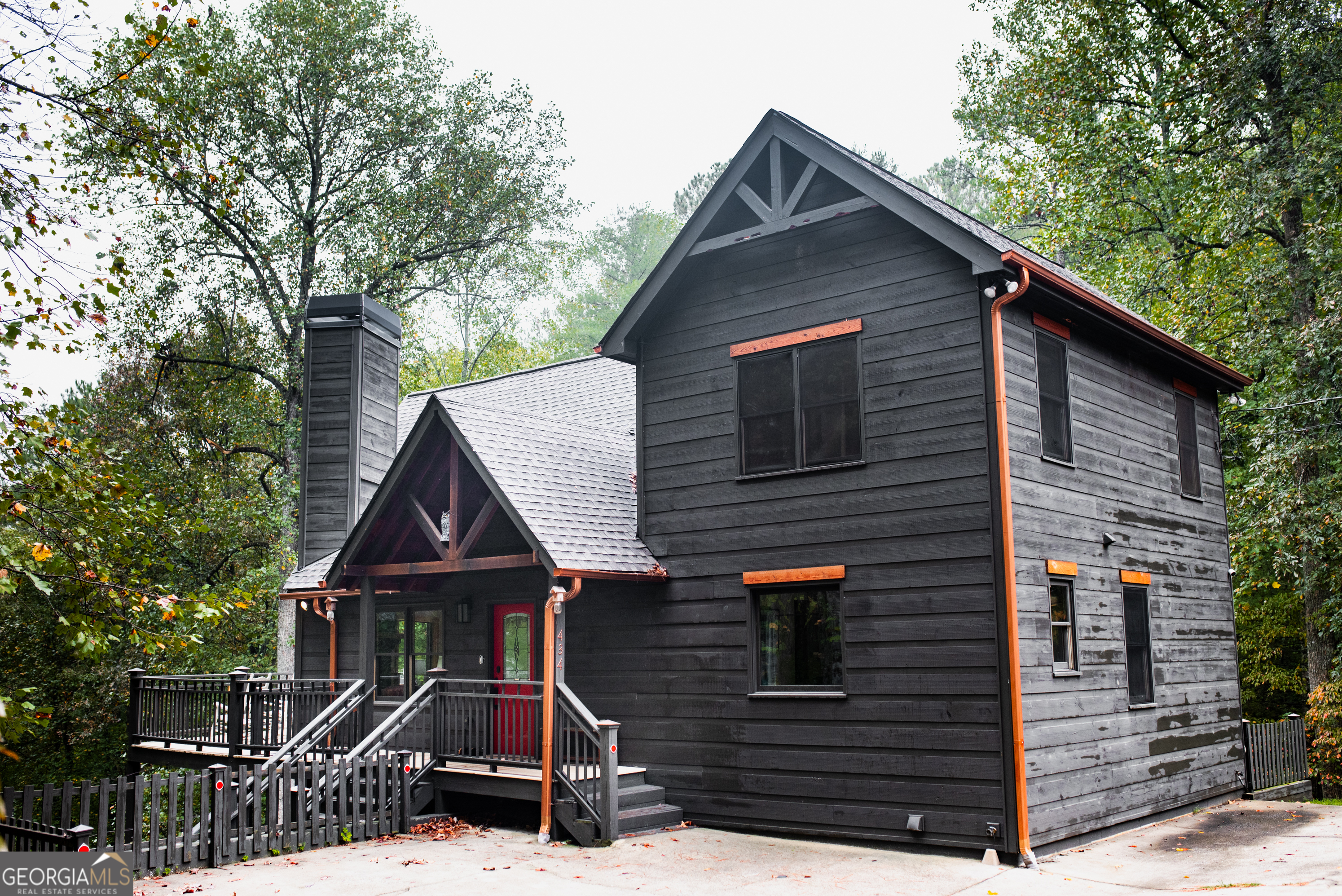 a front view of house with yard and trees in the background