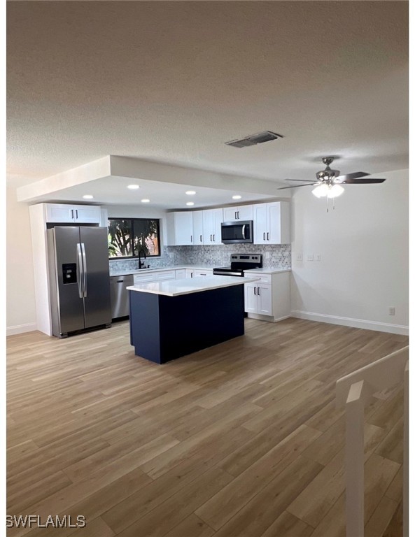 a large kitchen with stainless steel appliances a large counter top