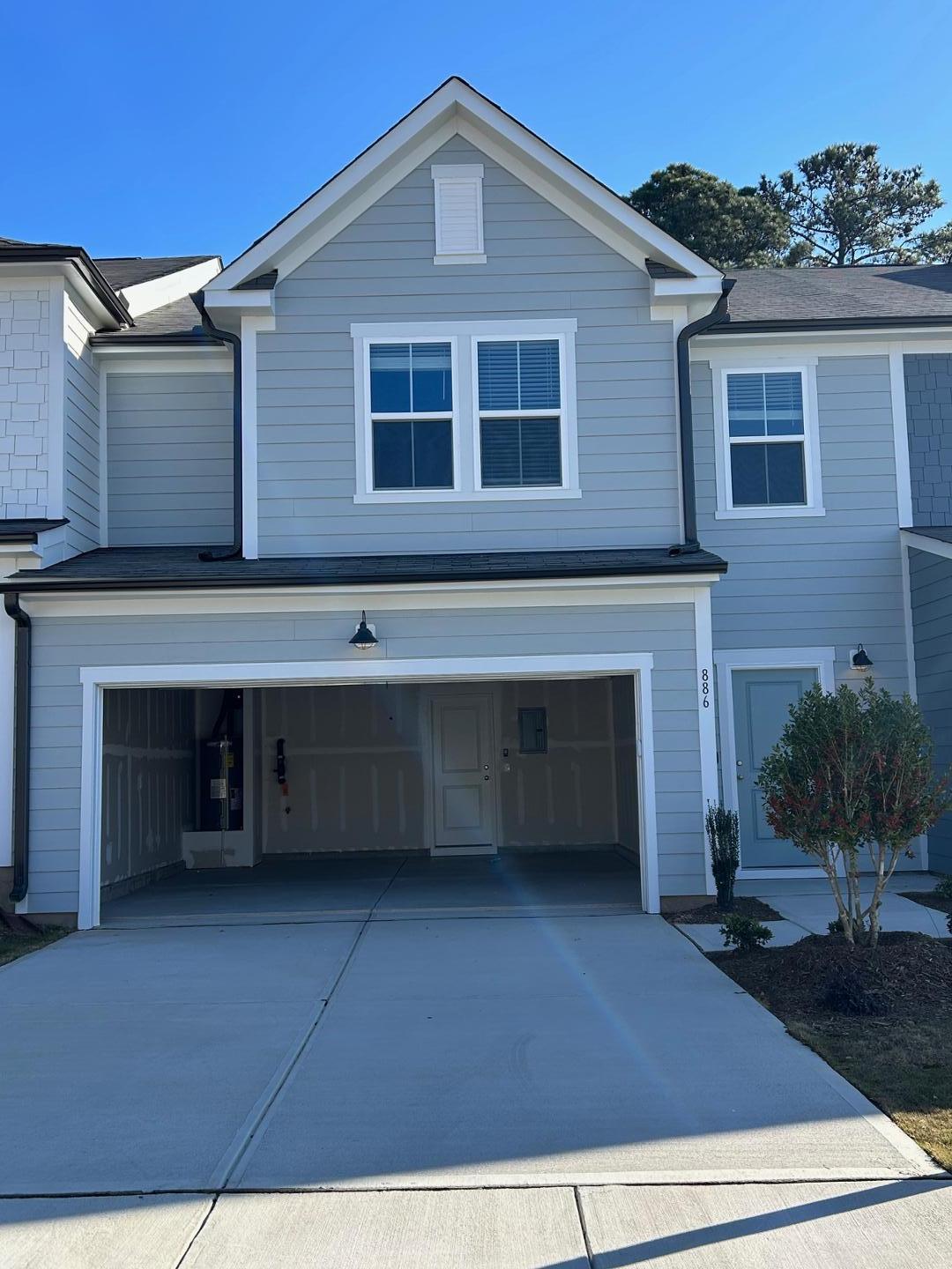 a view of a house with a yard and parking space