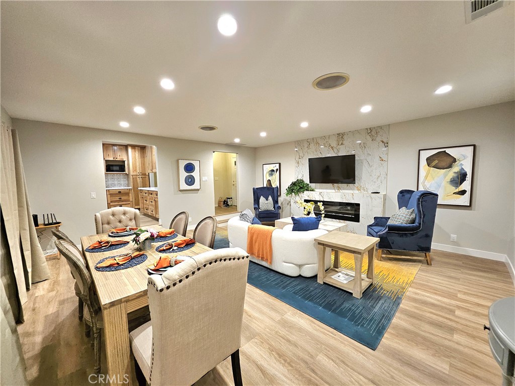 a living room with furniture a flat screen tv and kitchen view