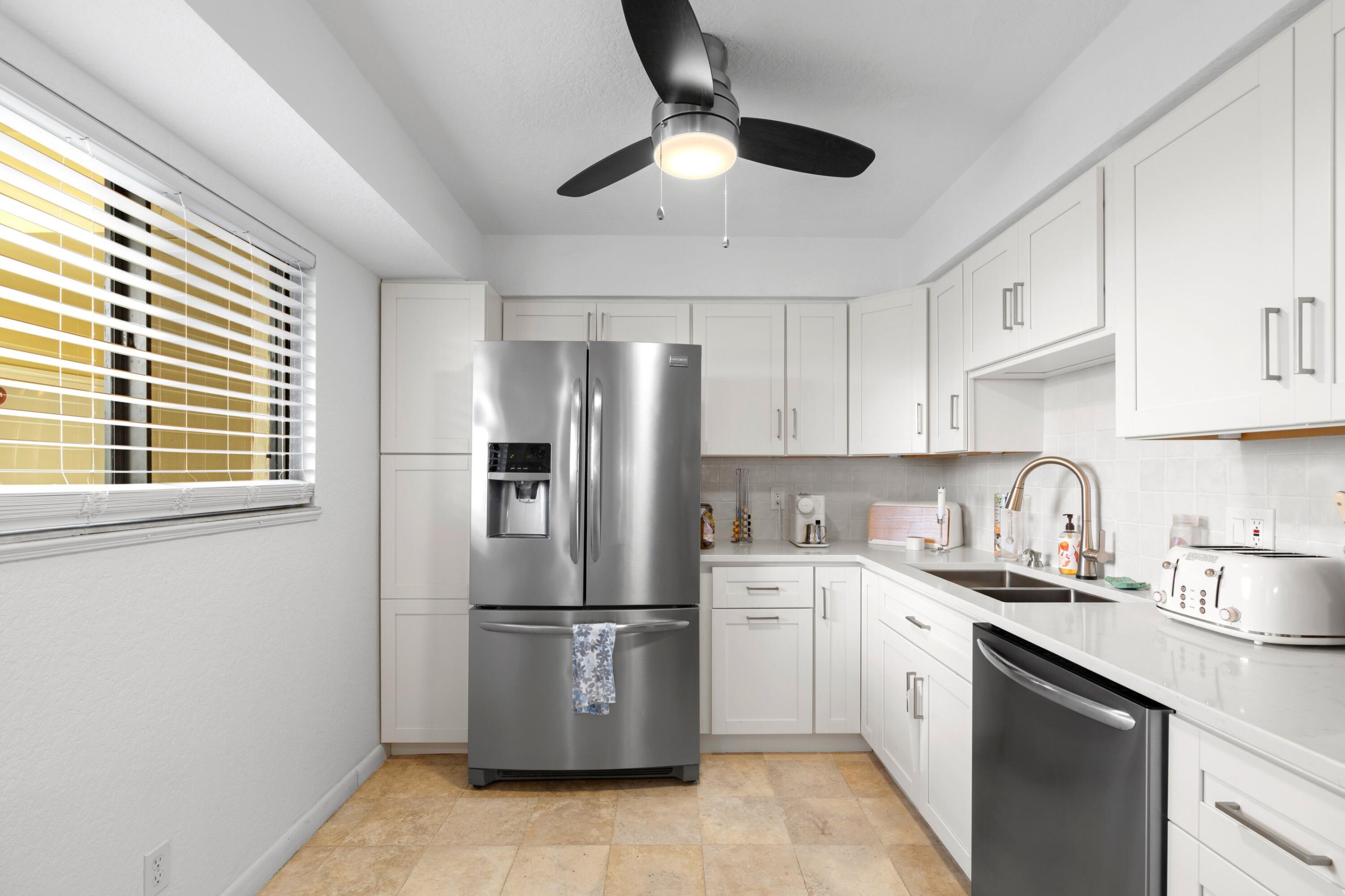 a kitchen with stainless steel appliances a refrigerator sink and cabinets