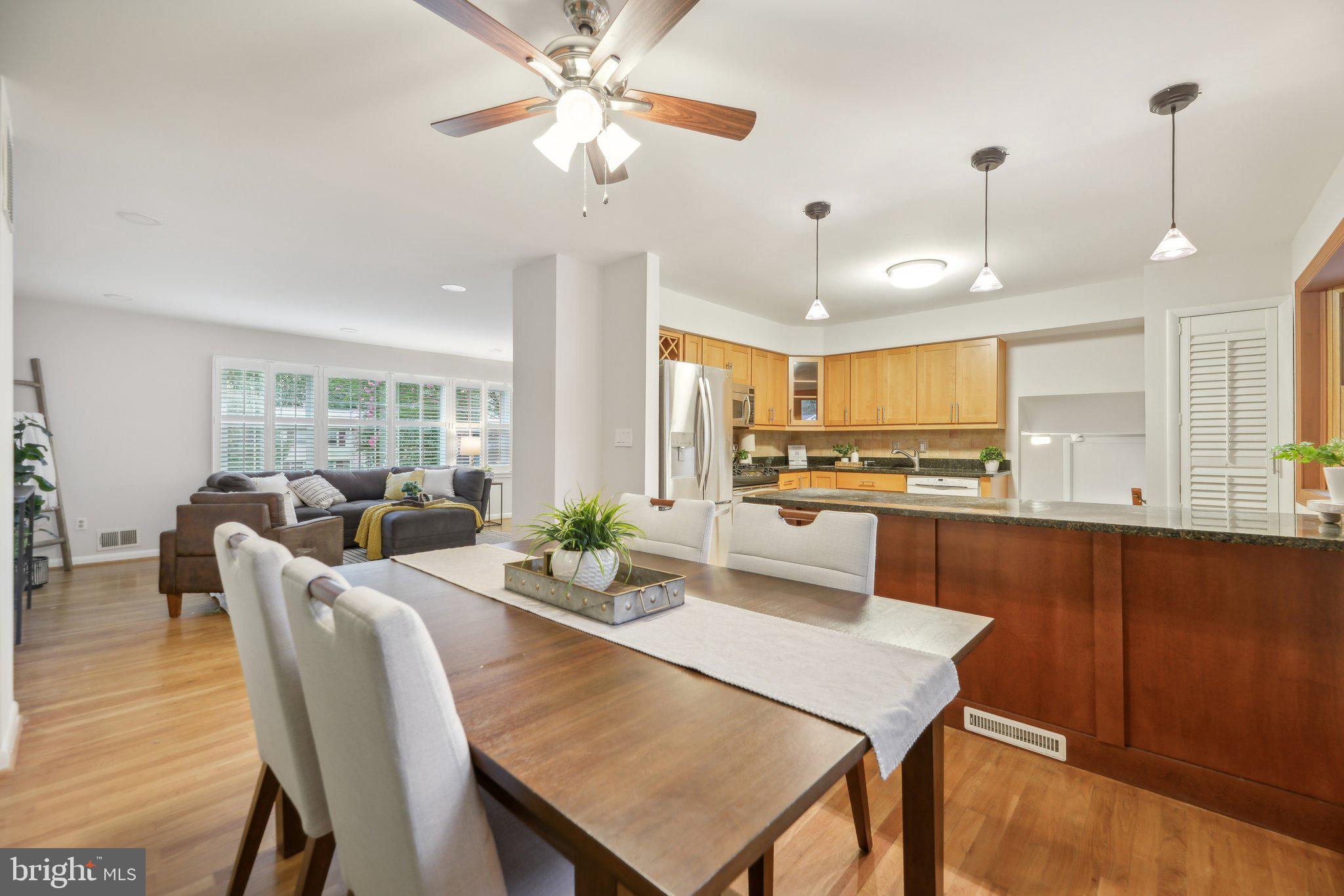 a view of a dining room and livingroom with furniture wooden floor a chandelier