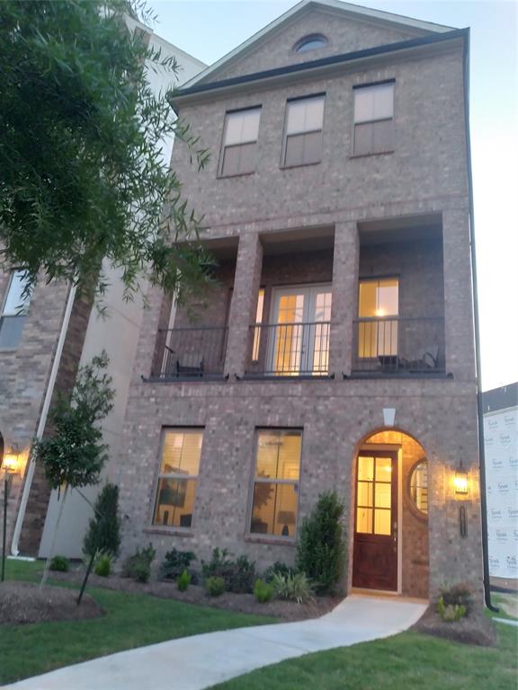 a front view of a multi story residential apartment building with yard and green space