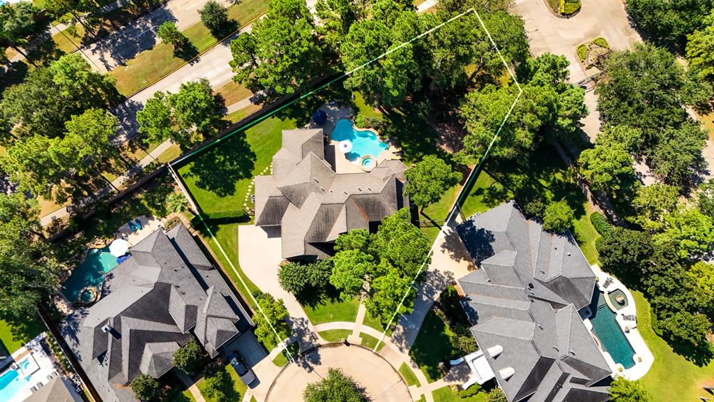 WOW WOW WOWAn aerial view showing the positioning of the home as it sits on the lot - offering a delightful retreat, amongst established shade trees, and offering a sparkling pool, raised spa, and beautiful shrubs and flowers. As well as a covered patio featuring an outdoor kitchen.