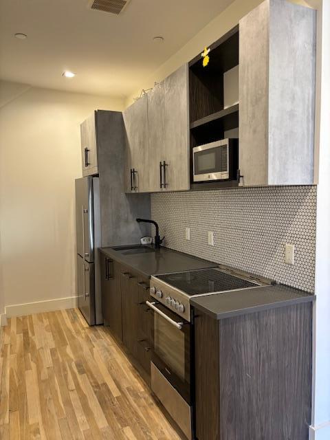 a kitchen with stainless steel appliances granite countertop a refrigerator and a stove top oven