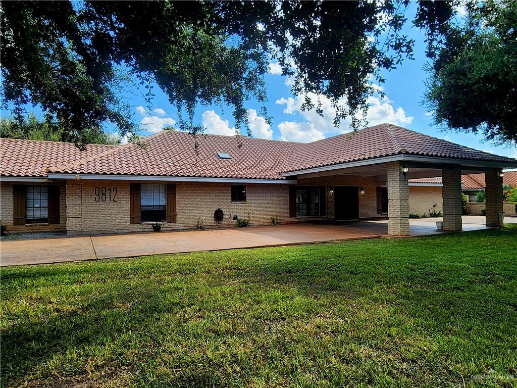 a view of a house with a yard and tree