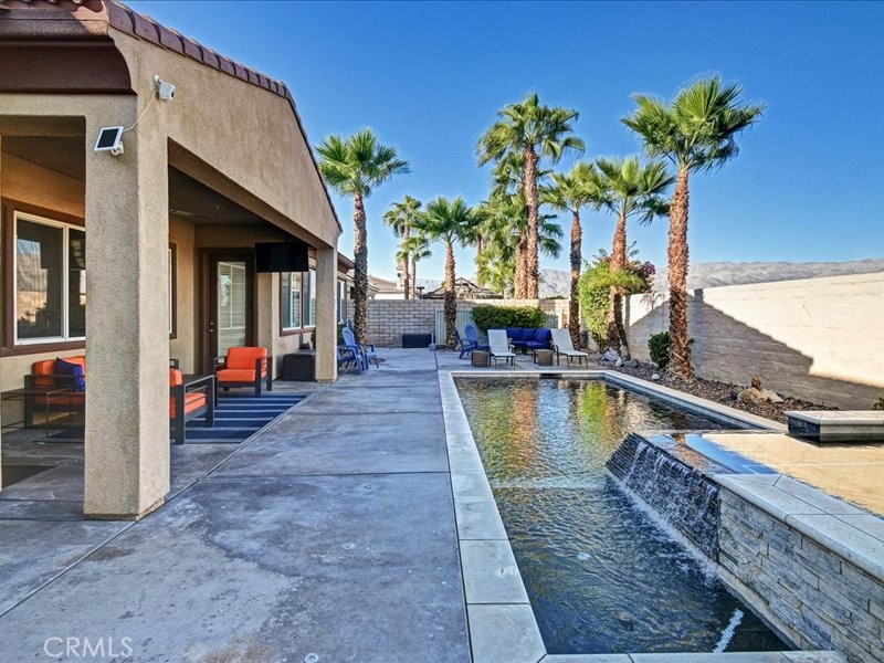 a view of a house with swimming pool and sitting area