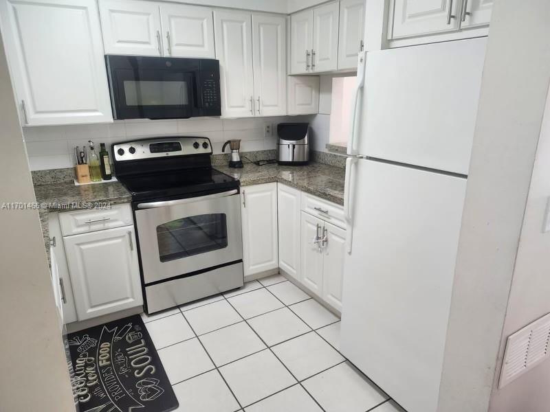 a kitchen with a stove top oven and cabinets