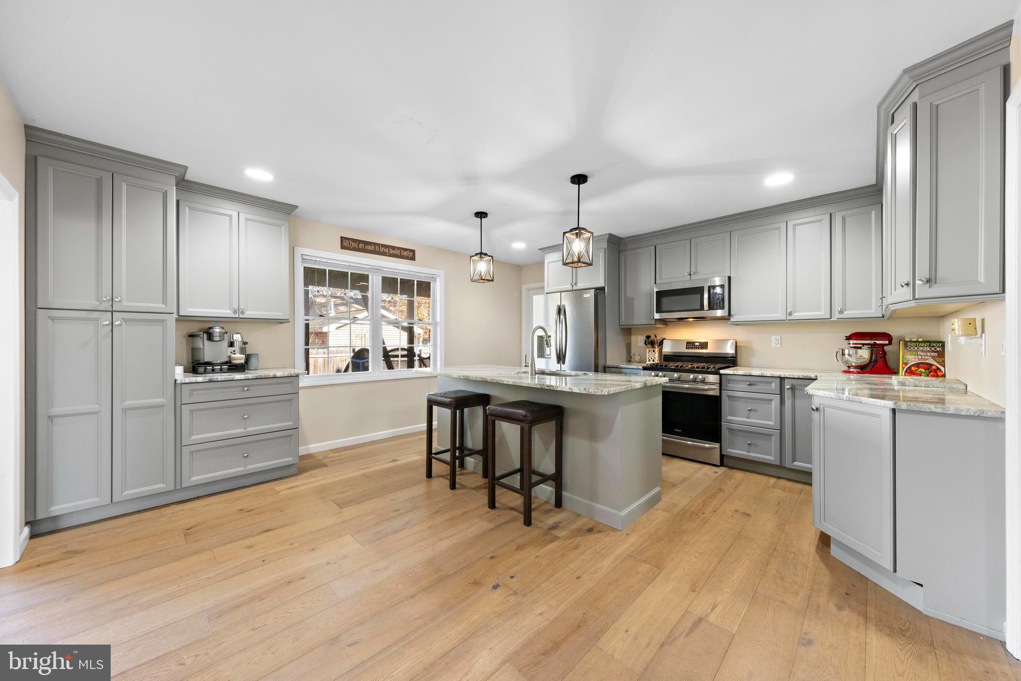 a kitchen with kitchen island granite countertop a sink cabinets and wooden floor