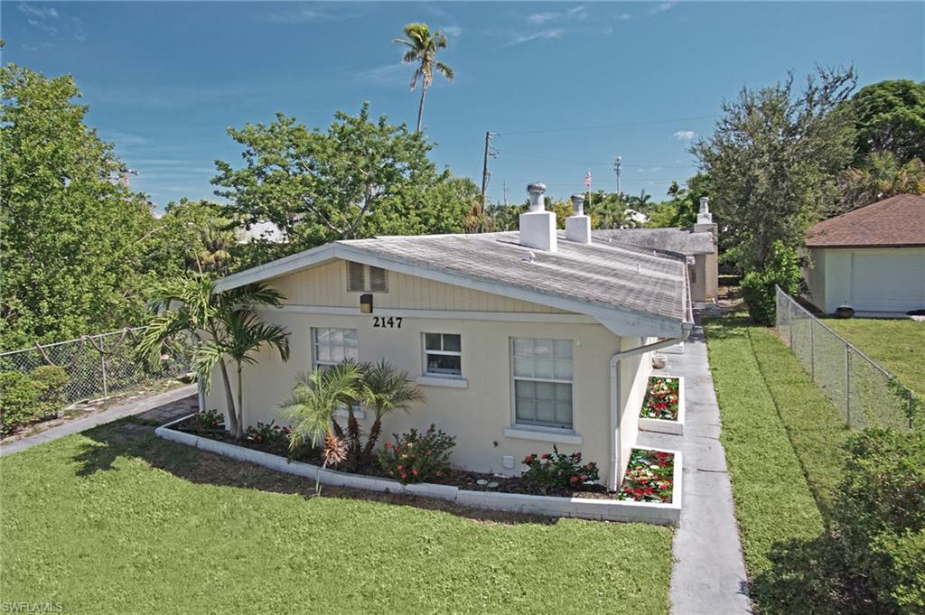 a view of a house with a yard and potted plants