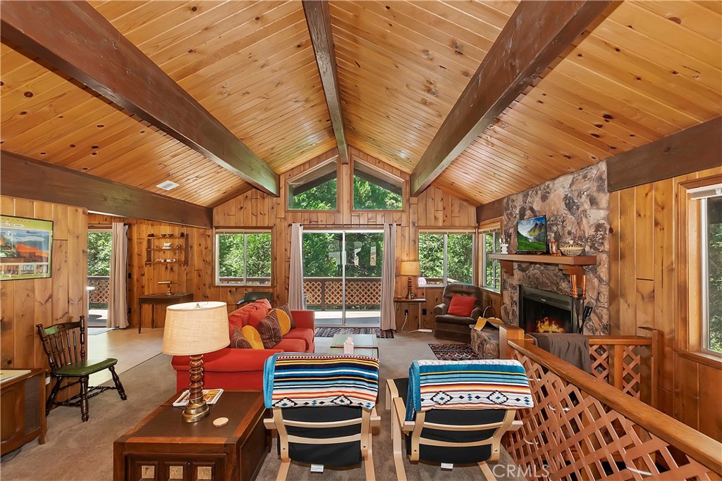 a living room with furniture a fireplace and a floor to ceiling window