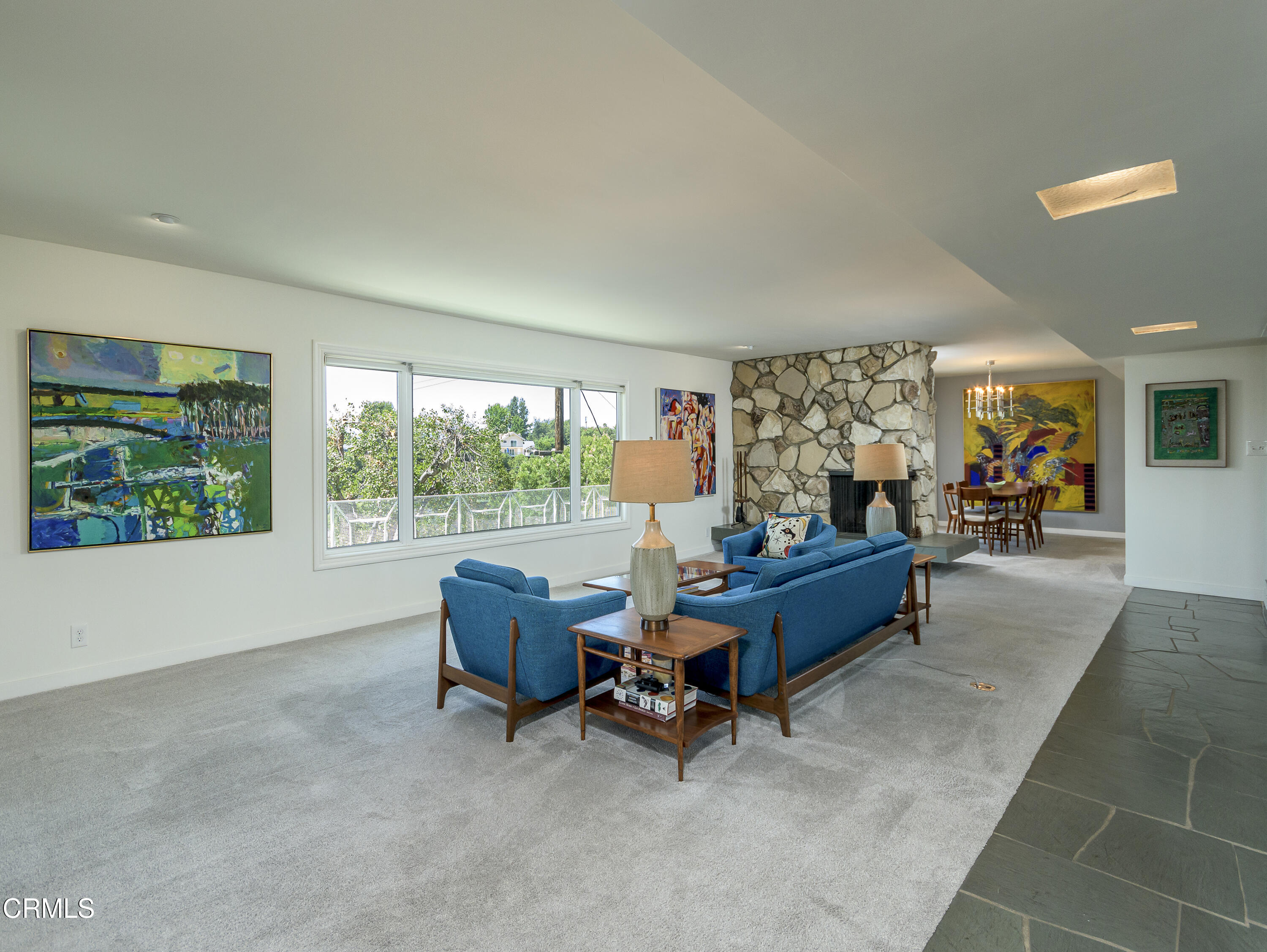 a living room with furniture and a floor to ceiling window