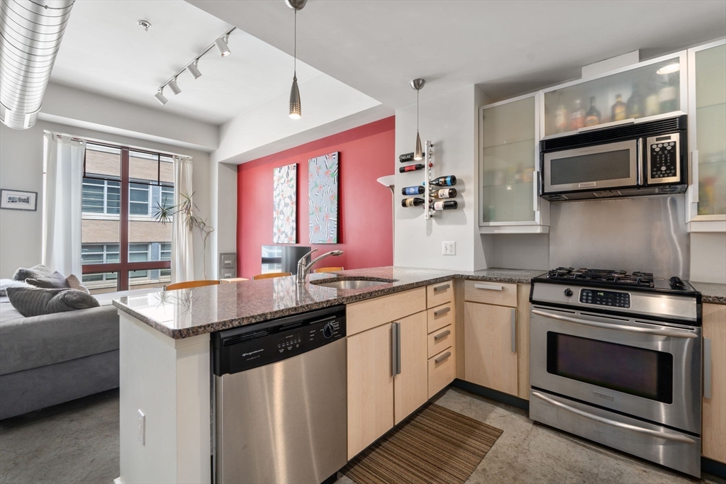 a kitchen with stainless steel appliances granite countertop a sink stove and microwave