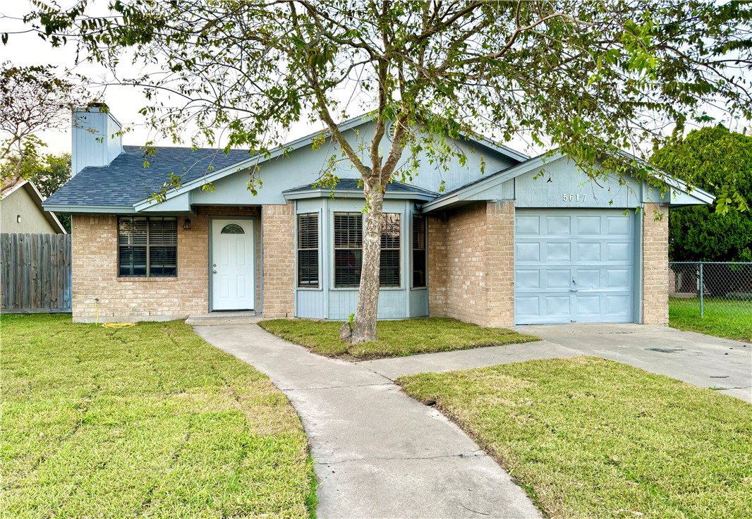 a front view of a house with a garden and yard